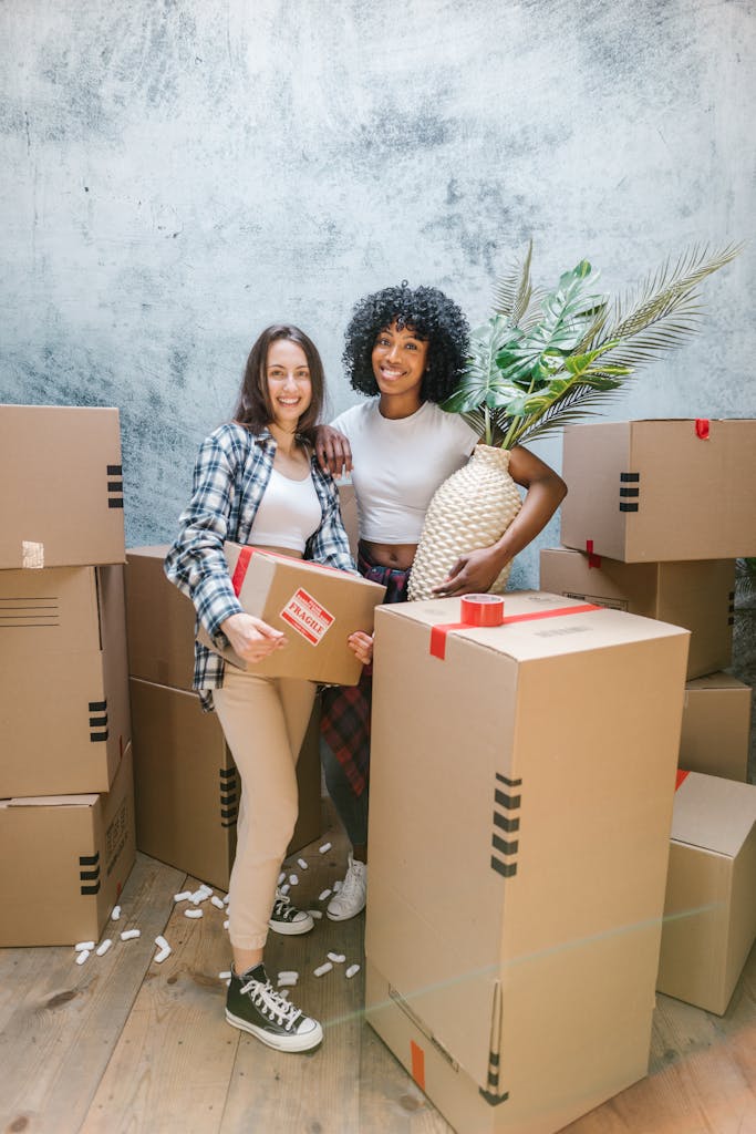 A happy couple packing boxes inside their new home, surrounded by moving supplies.