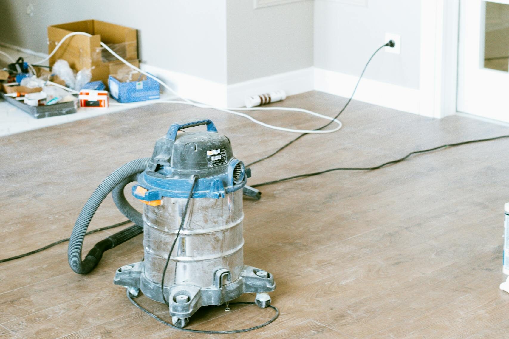 Vacuum and tools in a room undergoing renovation, showcasing home improvement.